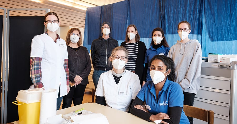 Gruppenbild von Menschen mit Maske, Personal bei Impfeinsatz