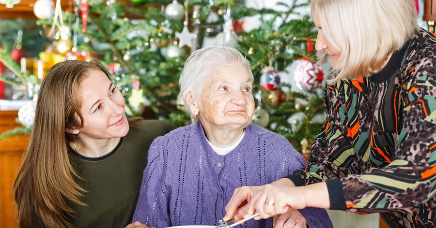 3 Generationen im weihnachtlich geschmückten Zimmer am Essenstisch