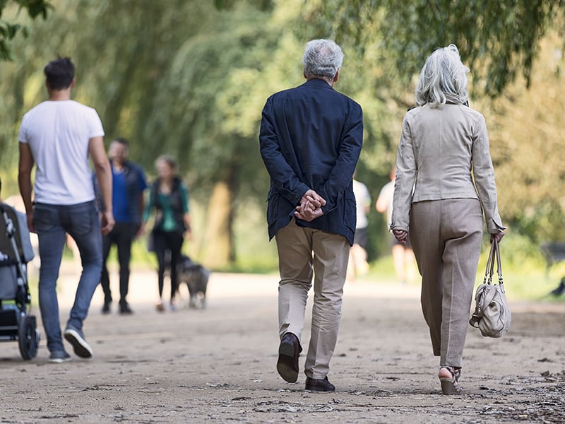 Älteres Ehepaar spaziert in einem Park, Sinnbild für alternde Bevölkerung